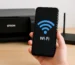 Celular mostrando ícone de Wi-Fi em frente a uma impressora Epson e roteador sobre a mesa 🗒️ Legenda